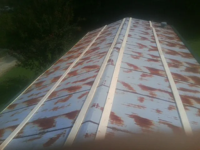 Rusted metal roof panels with new wood purlins before replacement — Storm Damage Roof Repair in Lafayette Hill by Roofing Brothers