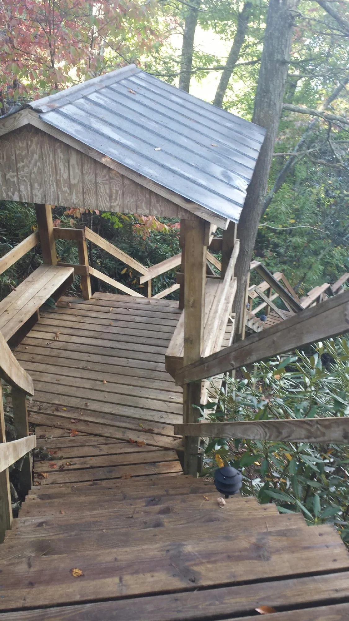 Metal roofed shelter over wooden steps on a wooded walkway — Skylight Repair & Installation work by our crew in Lafayette Hill